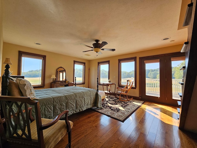 bedroom with ceiling fan, wood-type flooring, access to outside, and multiple windows