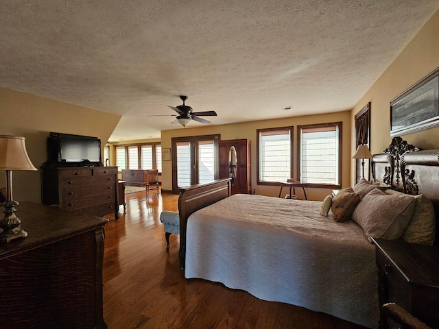 bedroom with ceiling fan, hardwood / wood-style floors, and a textured ceiling