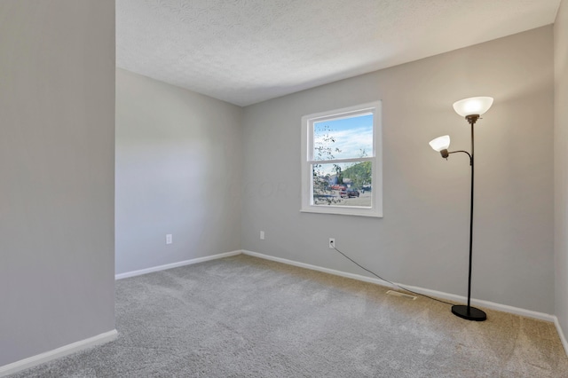 carpeted spare room with a textured ceiling