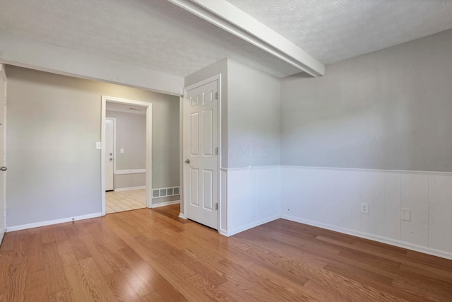 unfurnished room featuring hardwood / wood-style floors and a textured ceiling