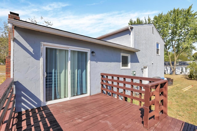 rear view of property featuring a lawn and a wooden deck