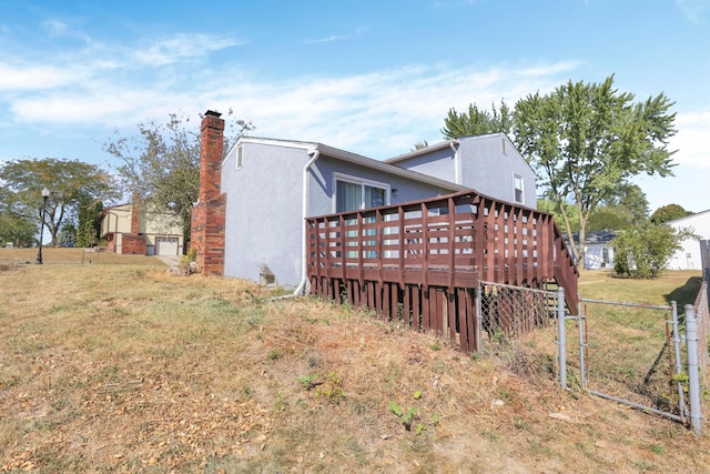 view of side of property featuring a yard and a deck