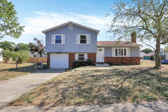 tri-level home featuring a garage and a front lawn