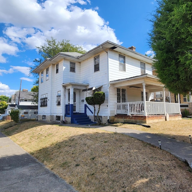 view of front of house featuring covered porch and a front yard