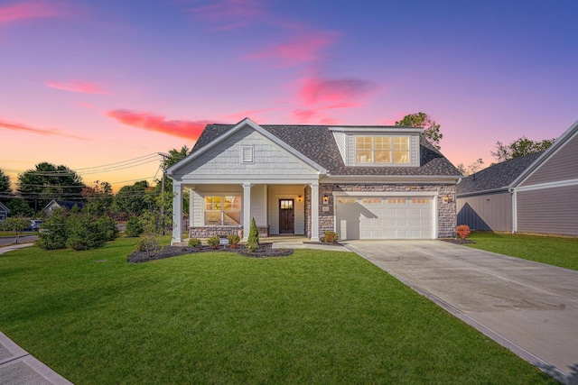 craftsman-style house featuring a porch, a garage, and a yard