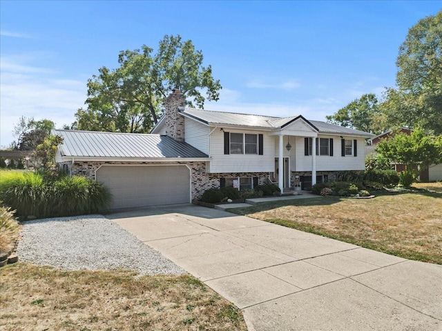 raised ranch featuring a front yard and a garage