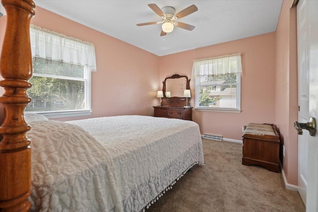 bedroom featuring carpet floors, baseboards, multiple windows, and visible vents