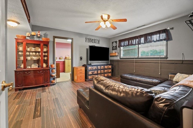 living room with hardwood / wood-style floors, ceiling fan, and a textured ceiling