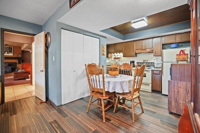 dining room with dark wood-type flooring and a textured ceiling