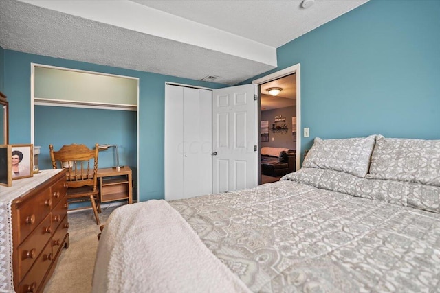 bedroom with light colored carpet and a textured ceiling