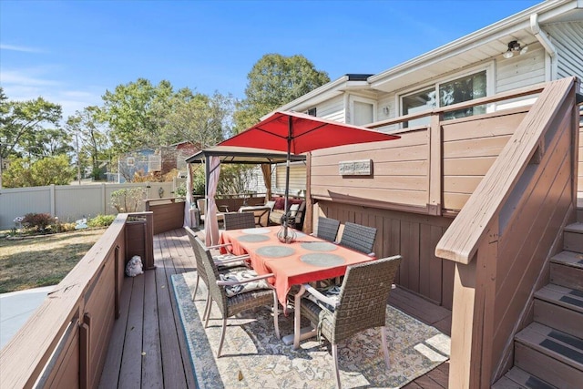 deck featuring outdoor dining area and fence