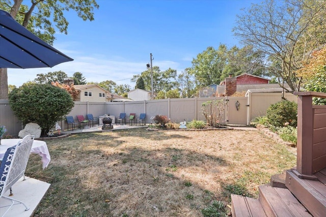 view of yard with a fire pit and a patio