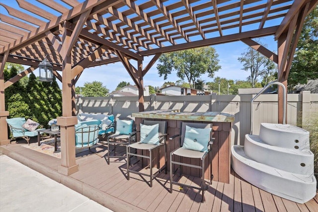 wooden terrace with fence, outdoor dry bar, and a pergola