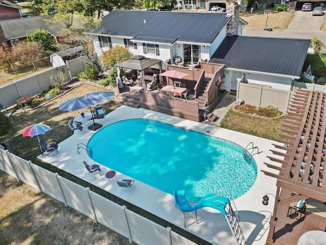 view of swimming pool with a fenced in pool, outdoor dining space, a fenced backyard, and a wooden deck