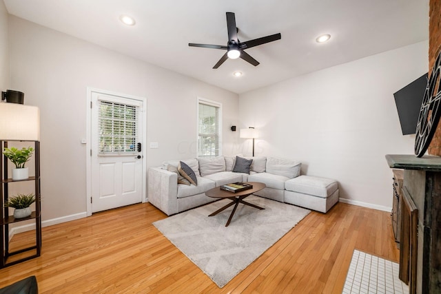 living room with ceiling fan and light hardwood / wood-style flooring