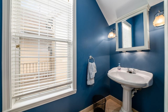 bathroom featuring tile patterned floors, lofted ceiling, and sink