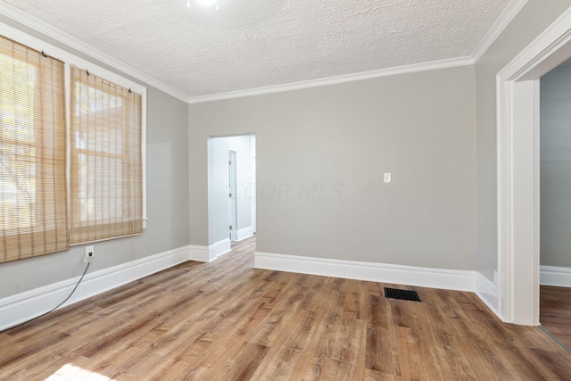 empty room with ornamental molding, a textured ceiling, and hardwood / wood-style flooring