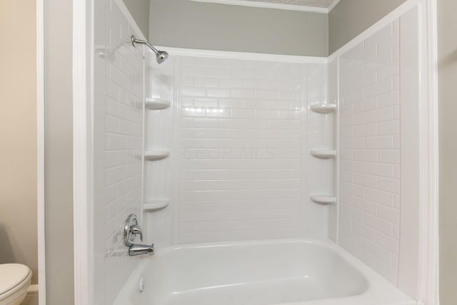 bathroom with toilet and tiled shower / bath