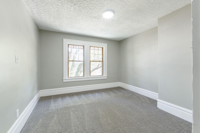 carpeted spare room with a textured ceiling