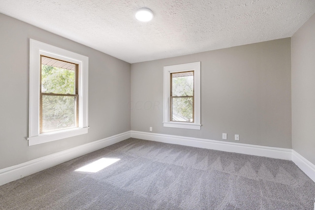 carpeted spare room featuring a textured ceiling