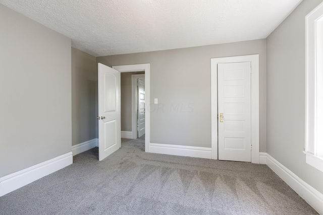 unfurnished bedroom with light carpet and a textured ceiling