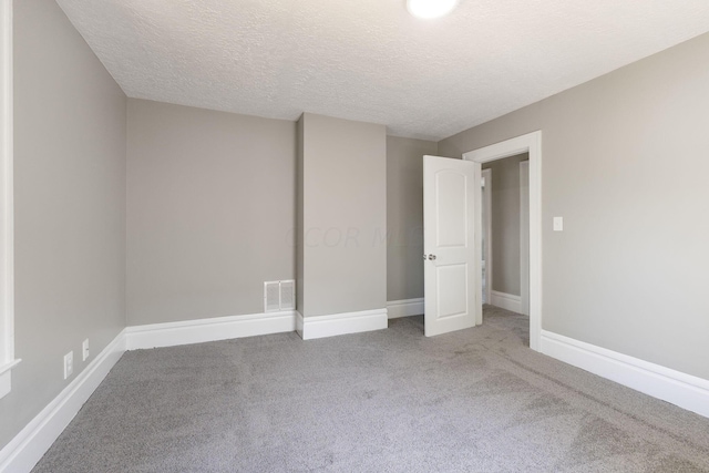 unfurnished bedroom featuring light colored carpet and a textured ceiling