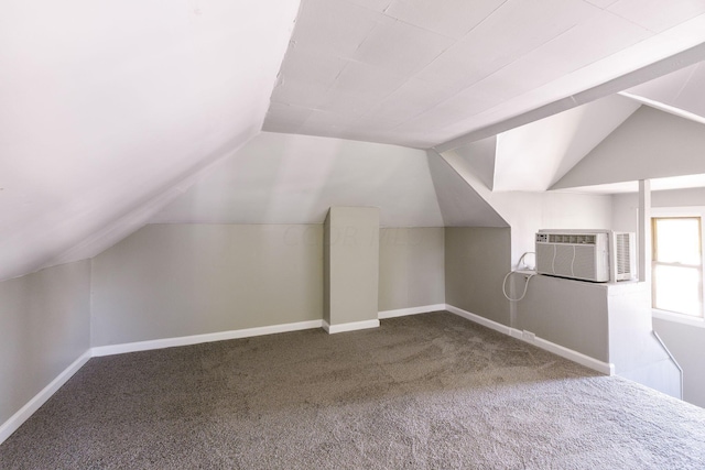 additional living space with a wall unit AC, carpet, and vaulted ceiling