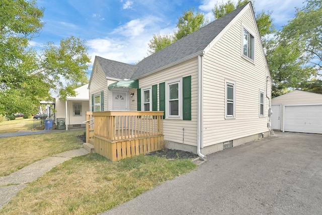 view of front of home with a front yard, a garage, and an outdoor structure