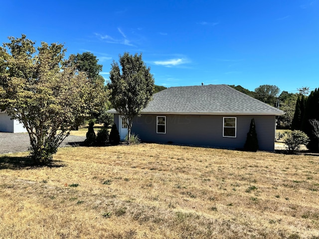 view of side of home with a yard