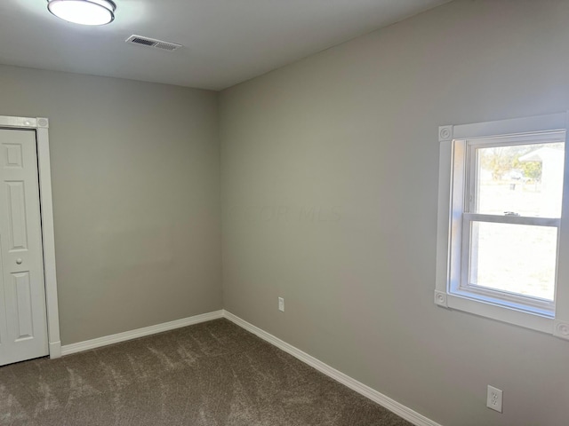 empty room with dark colored carpet