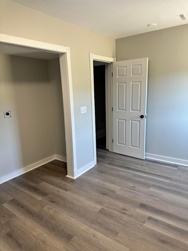 unfurnished bedroom featuring a closet and hardwood / wood-style flooring