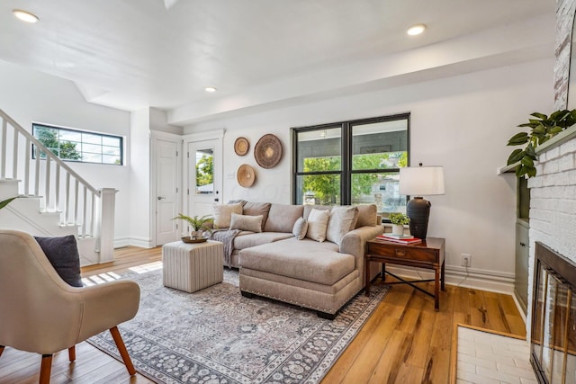 living room featuring hardwood / wood-style floors and a brick fireplace