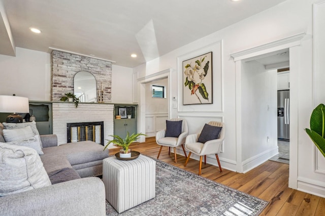 living room featuring light hardwood / wood-style floors and a brick fireplace