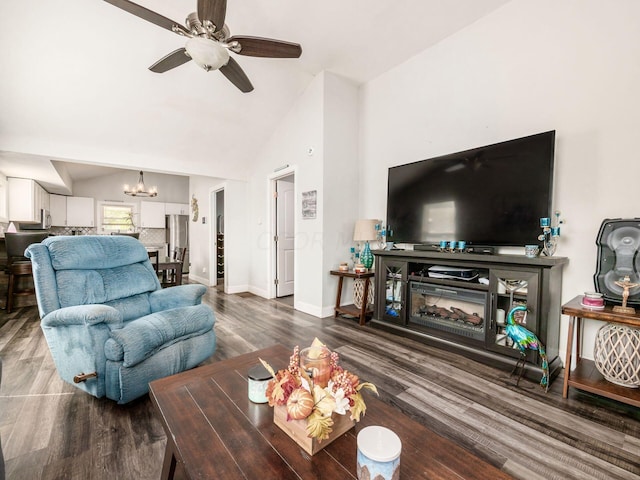 living room featuring hardwood / wood-style floors, ceiling fan with notable chandelier, and vaulted ceiling