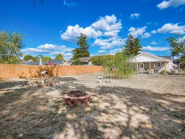 view of yard featuring covered porch and a fire pit