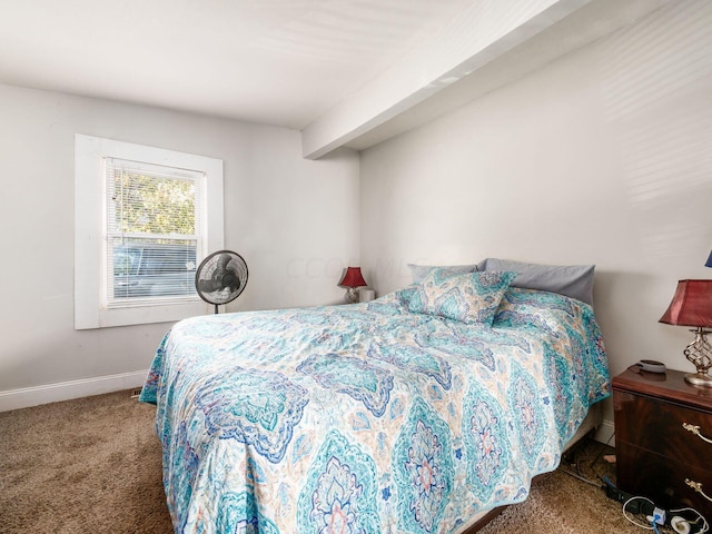 carpeted bedroom with beam ceiling