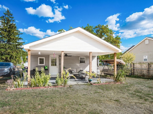 rear view of property with a lawn, ceiling fan, and an outdoor hangout area