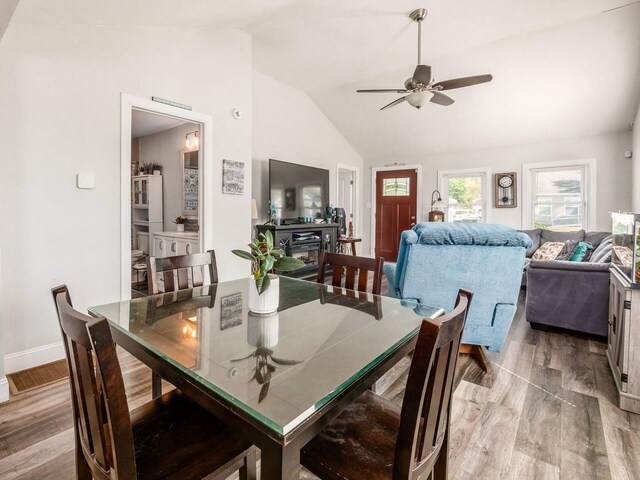 dining space with light hardwood / wood-style floors, high vaulted ceiling, and ceiling fan