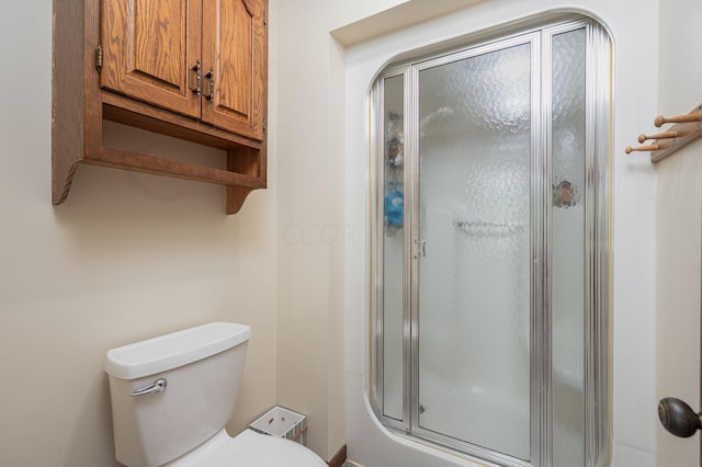 bathroom with toilet and a shower with door