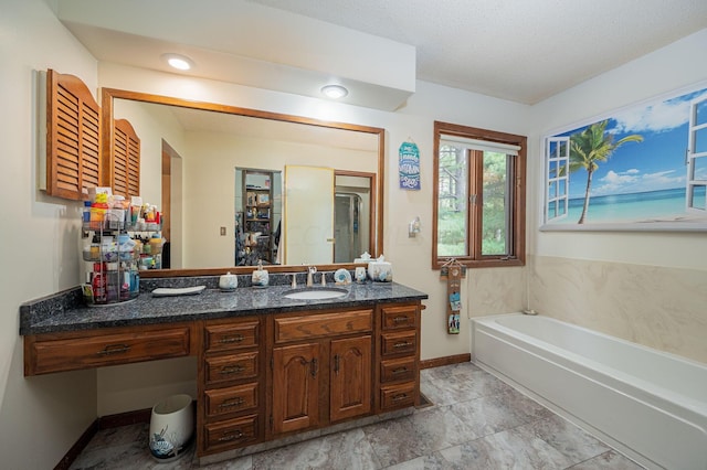 bathroom with a bath, a textured ceiling, and vanity