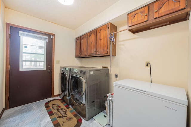 laundry area with separate washer and dryer, cabinets, and a textured ceiling