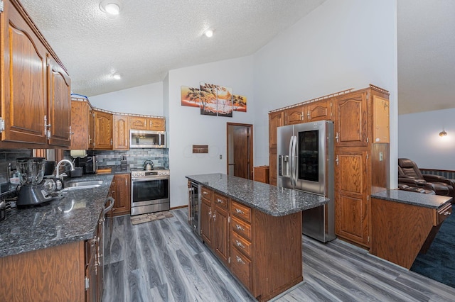 kitchen with appliances with stainless steel finishes, a center island, dark hardwood / wood-style floors, and tasteful backsplash