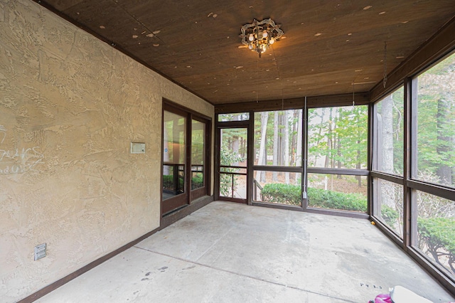 unfurnished sunroom with wood ceiling and a healthy amount of sunlight