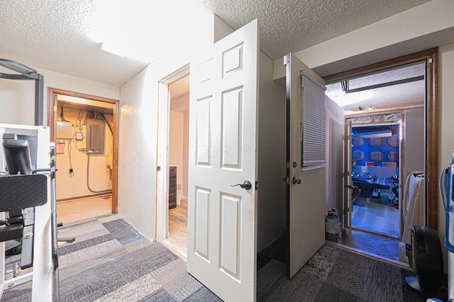 hall featuring wood-type flooring, a textured ceiling, and electric panel