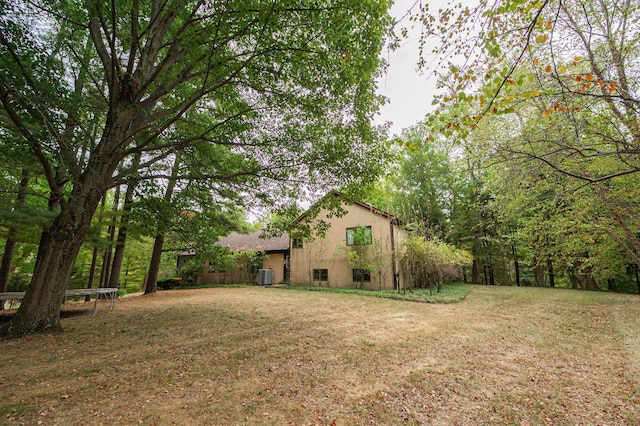 view of yard featuring central air condition unit and a trampoline