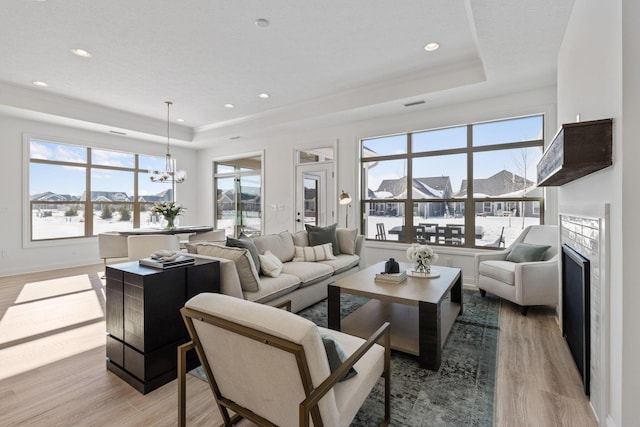 living room featuring light wood-style floors and a raised ceiling