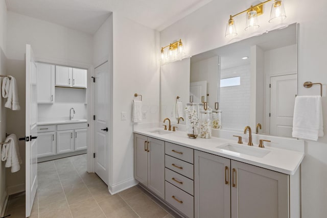 bathroom with double vanity, a sink, and baseboards