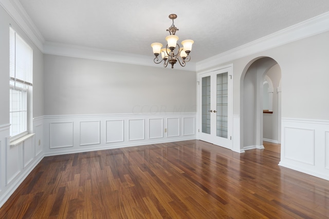 spare room with dark hardwood / wood-style floors, ornamental molding, and a chandelier