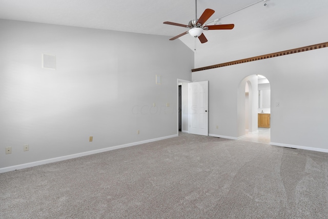 spare room featuring light carpet, high vaulted ceiling, and ceiling fan