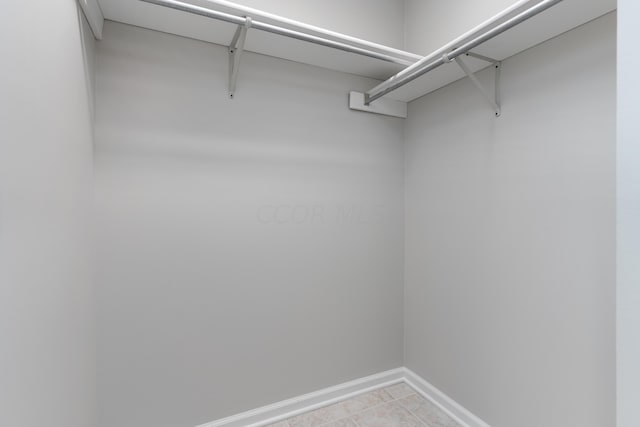 walk in closet with light tile patterned floors